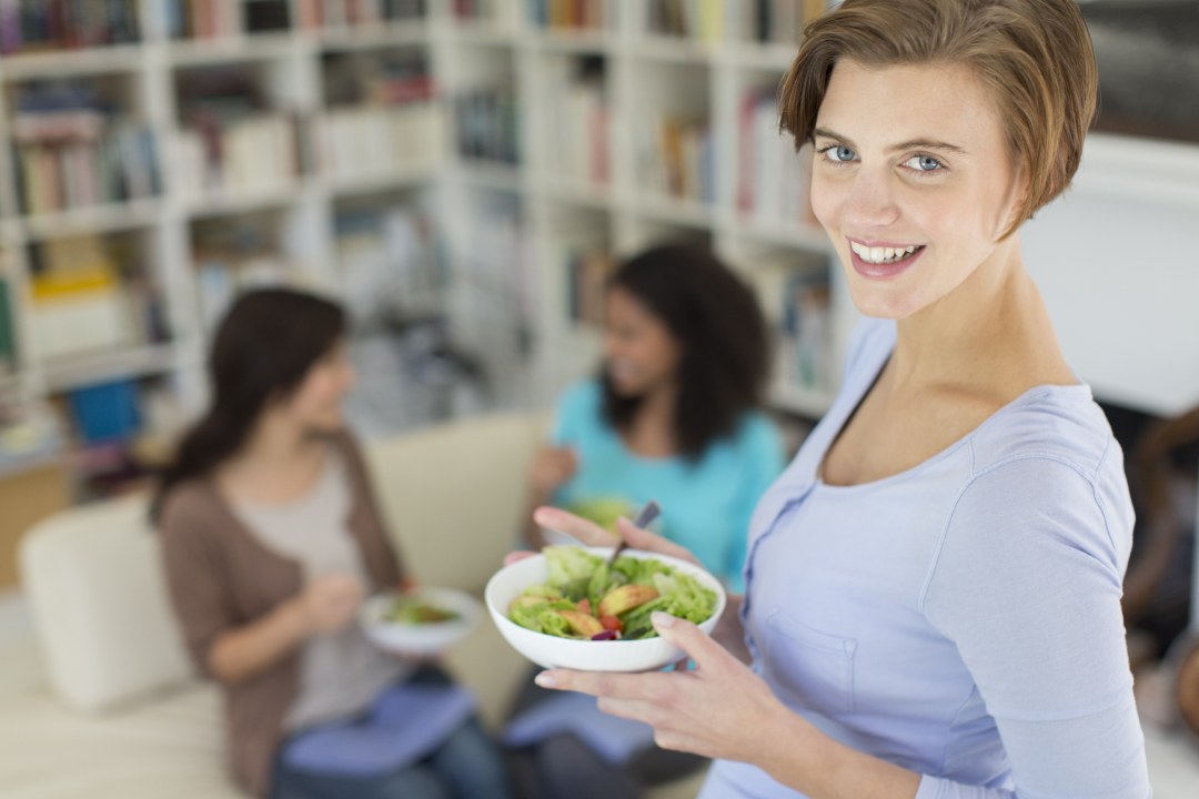 Mujer con un plato de salmón en la mano